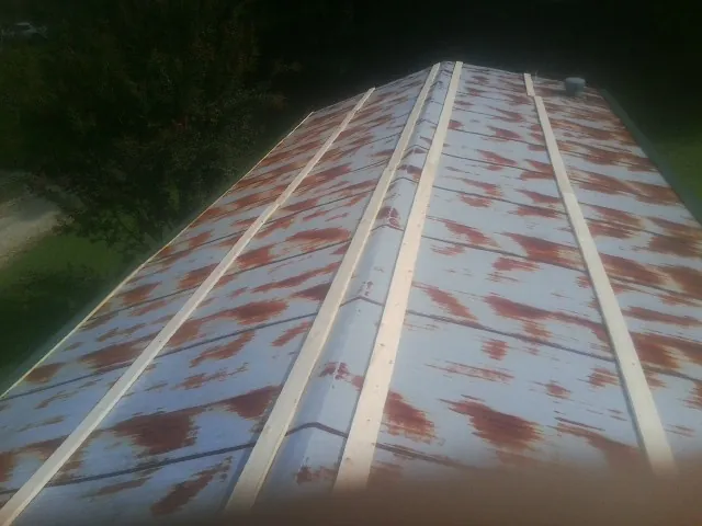 Rusted metal roof panels with new wood purlins before replacement — Storm Damage Roof Repair in Beachwood by Roofing Brothers