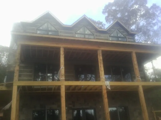 Dormers and porch framing on a large log home under construction — Roof Coating work by our crew in Beachwood